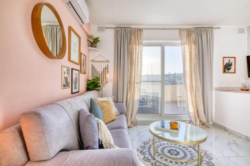 a living room with a couch and a table at Bright spacious getaway close to the Sea in Il-Gżira