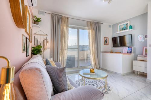 a living room with a couch and a table at Bright spacious getaway close to the Sea in Il-Gżira