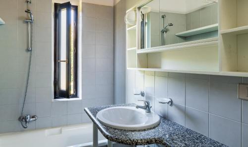 een badkamer met een wastafel en een ligbad bij Villetta 12 in Costa Rei