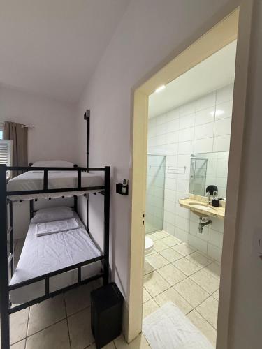 a room with a bunk bed and a bathroom at LumeHostel in João Pessoa