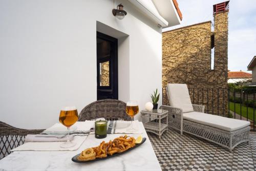 a table with a plate of food and two glasses of wine at La Playa Suites Suances in Suances