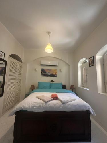 a bedroom with a large bed with blue pillows at chalet in nubian villas , behind Rihanna hotel in Hurghada