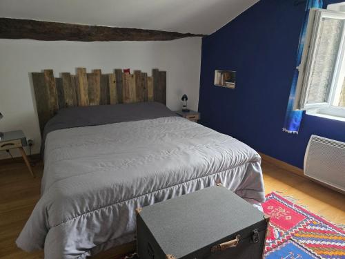 a bedroom with a bed and a blue wall at Gîte La Magnanerie in Reilhanette