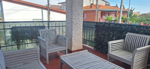 zwei Stühle und eine Stange auf einem Balkon in der Unterkunft La Tenería Chalet in El Tiemblo