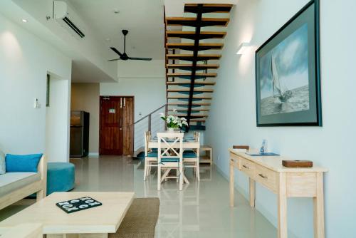a living room with a staircase and a table and chairs at Oceanfront Galle by ICC in Galle