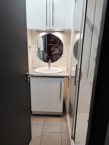 une salle de bain avec un lavabo et un miroir dans l'établissement studio bord de mer, à Santa-Lucia-di-Moriani