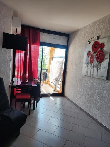 - un salon avec une table et un rideau rouge dans l'établissement studio bord de mer, à Santa-Lucia-di-Moriani
