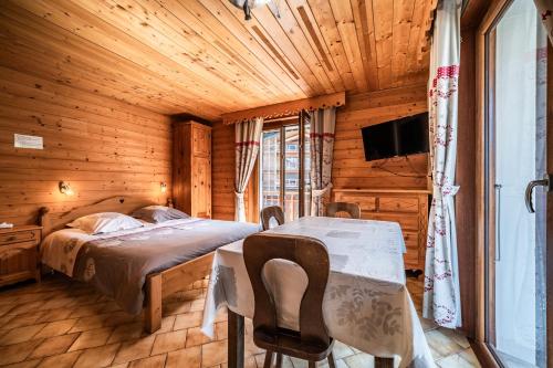 a bedroom with a bed and a table and a tv at La Flèche d'Or in Châtel