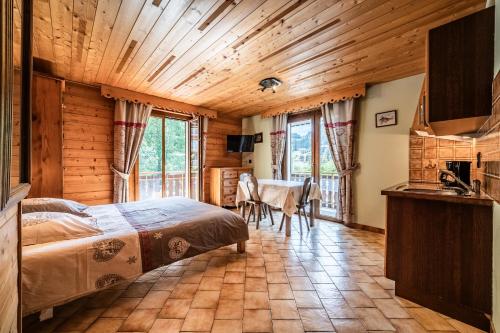 a bedroom in a log cabin with a bed and a table at La Flèche d'Or in Châtel