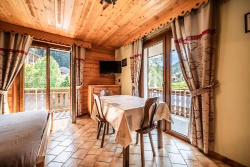 a dining room with a table and a large window at La Flèche d'Or in Châtel