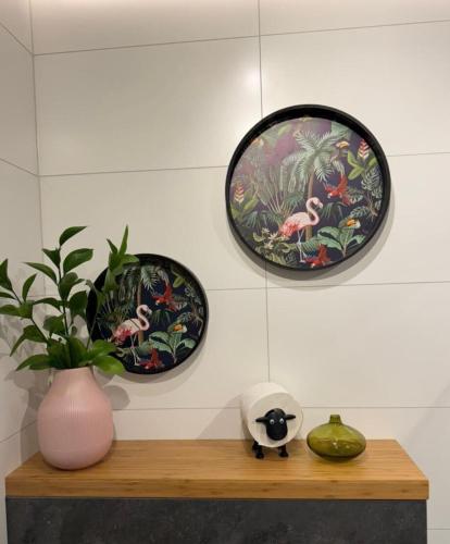 a shelf with three plates and a potted plant on it at Luxury row house in quiet area with infrared sauna and hot tub in Mosfellsbær