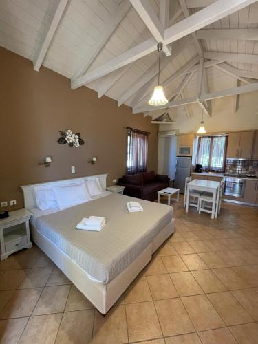 a bedroom with a large bed and a kitchen at Kolokotronis Hotel & Spa in Stoupa
