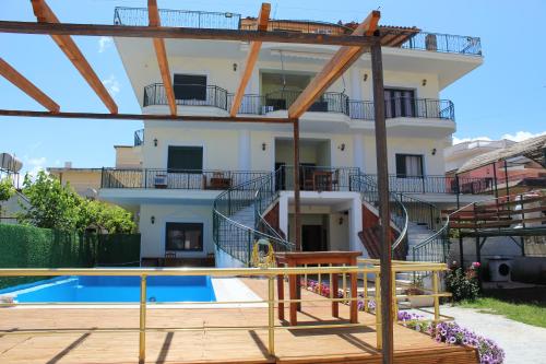 a villa with a swimming pool and a house at Hotel VANGJELI Orikum in Orikum