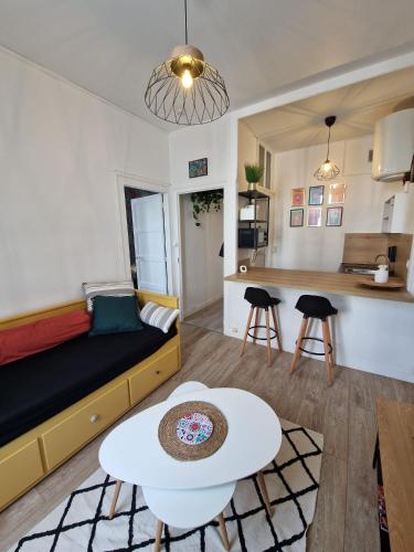 Cette chambre comprend un lit, une table et une cuisine. dans l'établissement Le Savary appart centre-ville près des Chantiers, à Saint-Nazaire