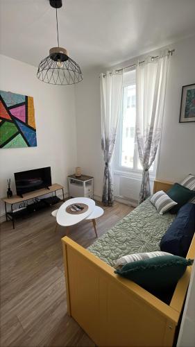 - un salon avec un lit et une table dans l'établissement Le Savary appart centre-ville près des Chantiers, à Saint-Nazaire