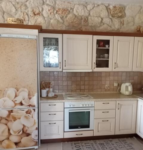 a kitchen with white cabinets and a refrigerator at Siviri Traditional Stone House in Siviri