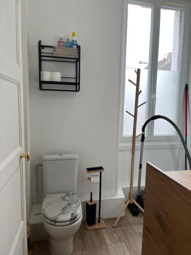 une salle de bain blanche avec toilettes et fenêtre dans l'établissement Le Savary appart centre-ville près des Chantiers, à Saint-Nazaire