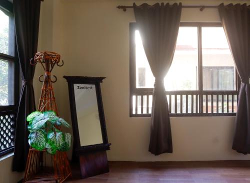 a mirror in a room with windows with curtains at Zen Nest Hotel in Kathmandu
