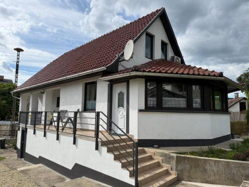a small white house with a brown roof at Kamilla Vendégház in Mád