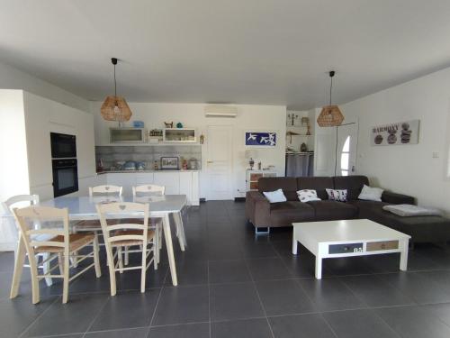 un salon avec un canapé, une table et des chaises dans l'établissement VILLA climatisée tout confort Proche mer et montagne 3 chbres, à Campodiloro