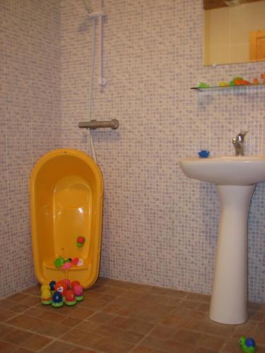 La salle de bains est pourvue d'un lavabo et d'un urinoir jaune. dans l'établissement Limerac Child Friendly Farmhouse, à Salles-Lavalette