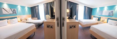 a hotel room with two beds and a desk at Hampton By Hilton Bristol Airport in Redhill