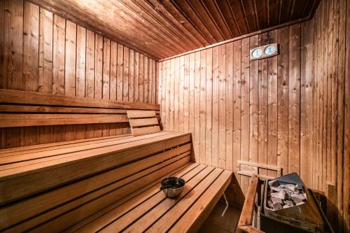 a wooden sauna with a bench and a bucket in it at La Flèche d'Or in Châtel