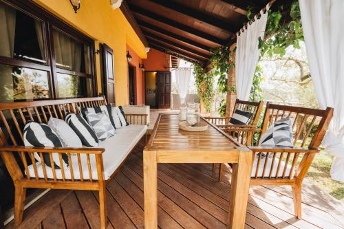 a porch with a wooden table and chairs on a deck at NEW!!! La Magrina - Bed&Breakfast in Vrsar