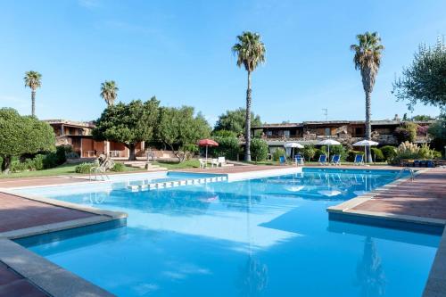 ポルト・ロトンドにあるApp Porto Rotondoのヤシの木が背景に広いスイミングプール