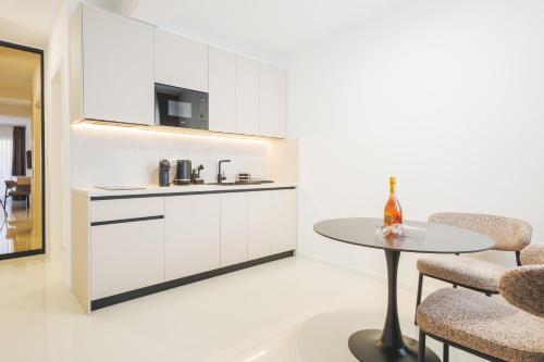 a kitchen with white cabinets and a table and chairs at Apartments Maritea in Vodice