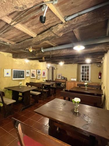 a restaurant with wooden tables and chairs and a room with tables at Associação Quinta das Relvas in Branca