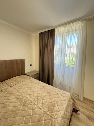 a bedroom with a bed and a large window at Armani in Yeghegnadzor