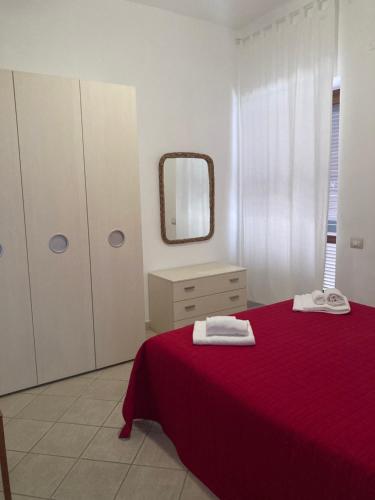 a bedroom with a red bed and a mirror at Il Casalino in Maratea