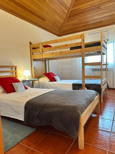 two bunk beds in a room with wooden ceilings at Casa d'Avó Maria - Paraíso no campo - 10pax, com piscina, vistas e vinhas in Marco de Canaveses