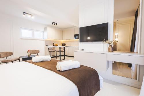 a bedroom with a bed and a tv and a kitchen at Apartments Maritea in Vodice