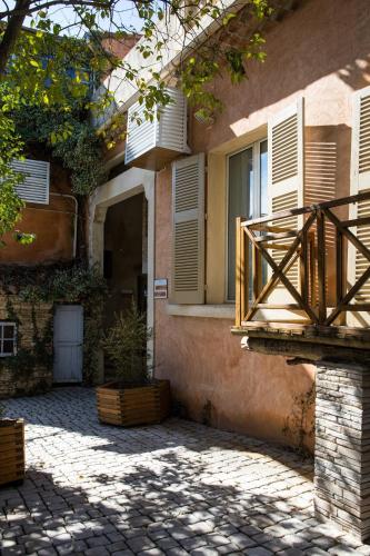 a building with a balcony and a patio at In Provence Hôtel - Expérience Authentique in Venelles