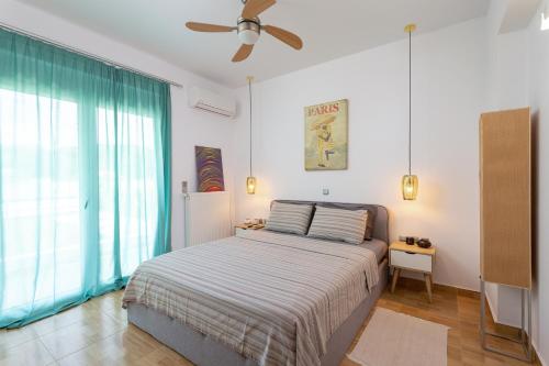 a bedroom with a bed and a ceiling fan at Villa Miniera in Linopótis