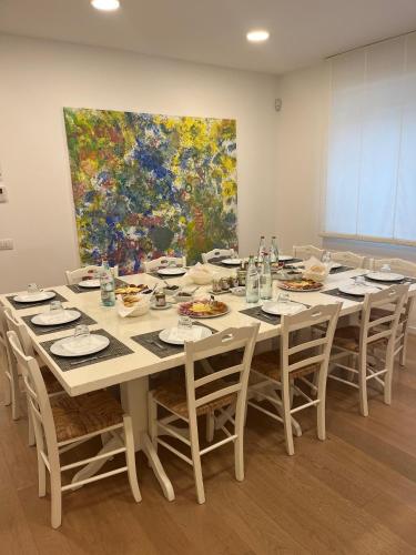 a large table with chairs and a painting on the wall at Agriturismo La Semente in Spello