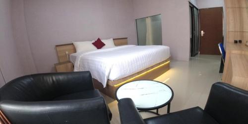 a hotel room with a bed and a chair at Great Cokro Edotel Lampung in Lampung