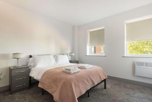a white bedroom with a bed and two windows at Spacious & Bright 1 Bed Flat in Central Doncaster in Doncaster