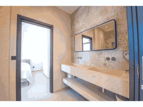 une salle de bain avec un lavabo et un miroir au mur dans l'établissement Villa de Vacances au Cœur de la Nature, à Cavalaire-sur-Mer