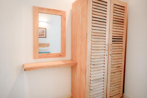 a mirror on a wall next to a wooden closet at Oceanfront Galle by ICC in Galle