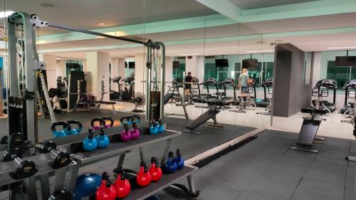 a gym with a row of exercise equipment and a mirror at Avana Bangkok Hotel & Convention Centre in Bangna