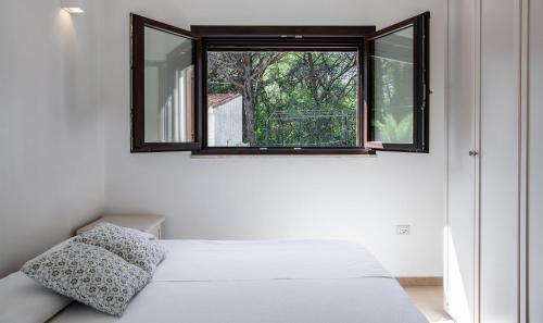 een slaapkamer met een wit bed en een raam bij Villa Lantana in Pula
