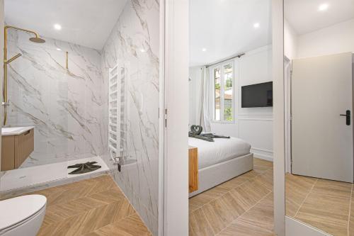 a bathroom with a sink and a toilet and a tv at SUITE DELUXE - MONACO - Vue Jardin in Beausoleil