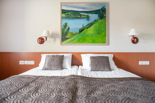 a bedroom with a bed with a painting on the wall at Art City Inn in Vilnius