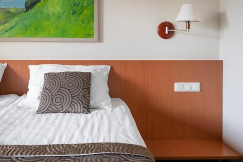 a bedroom with a bed with a wooden headboard at Art City Inn in Vilnius