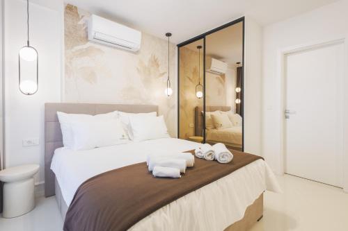 a bedroom with a large bed with towels on it at Apartments Maritea in Vodice