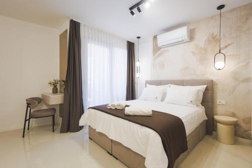 a bedroom with a large bed and a chair at Apartments Maritea in Vodice