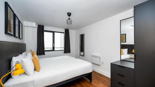 a bedroom with a white bed and a mirror at Staycity Aparthotels Liverpool City Centre in Liverpool